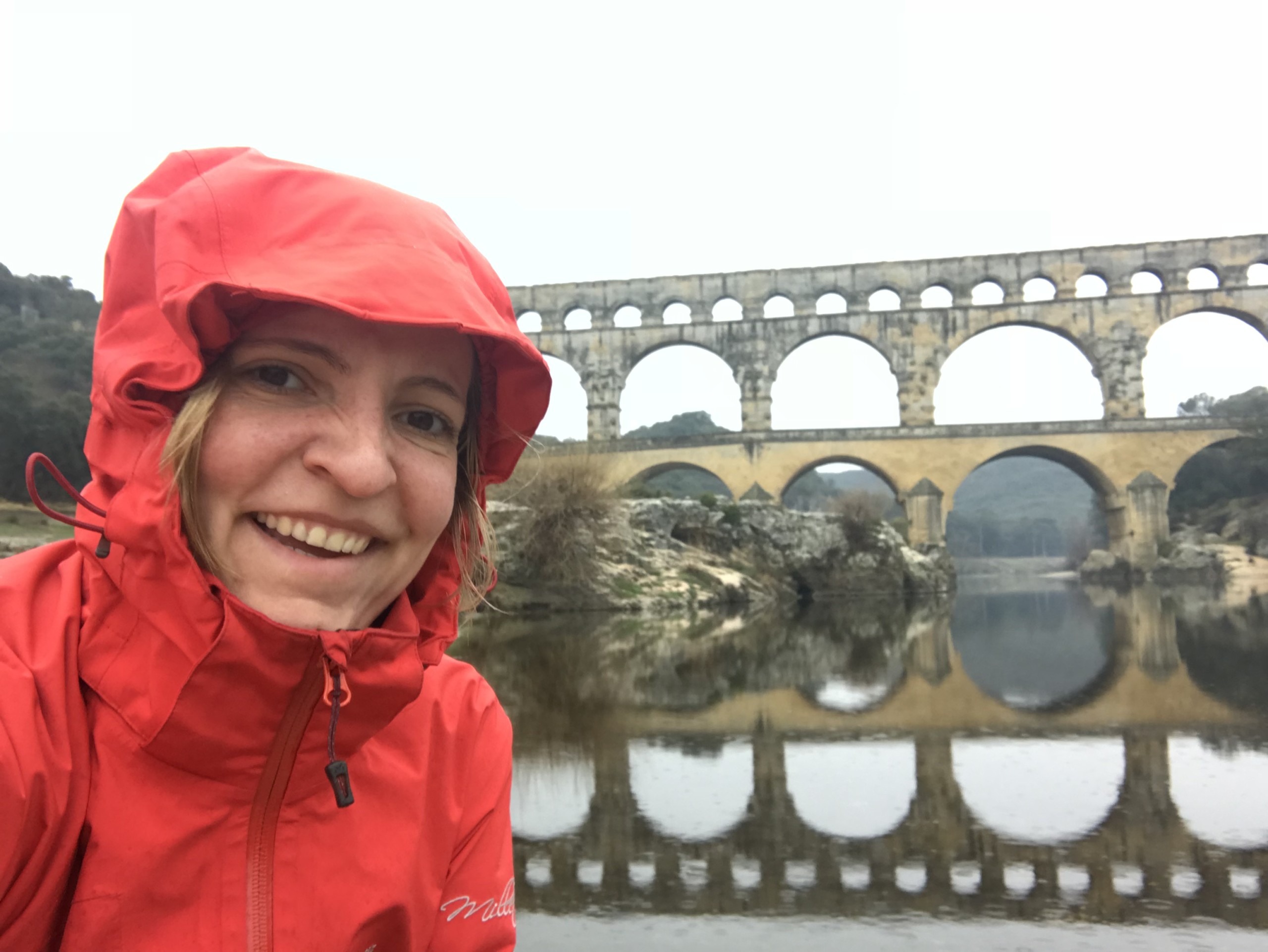 Rebecca in Regenjacke vor Pont du Gard in Frankreich
